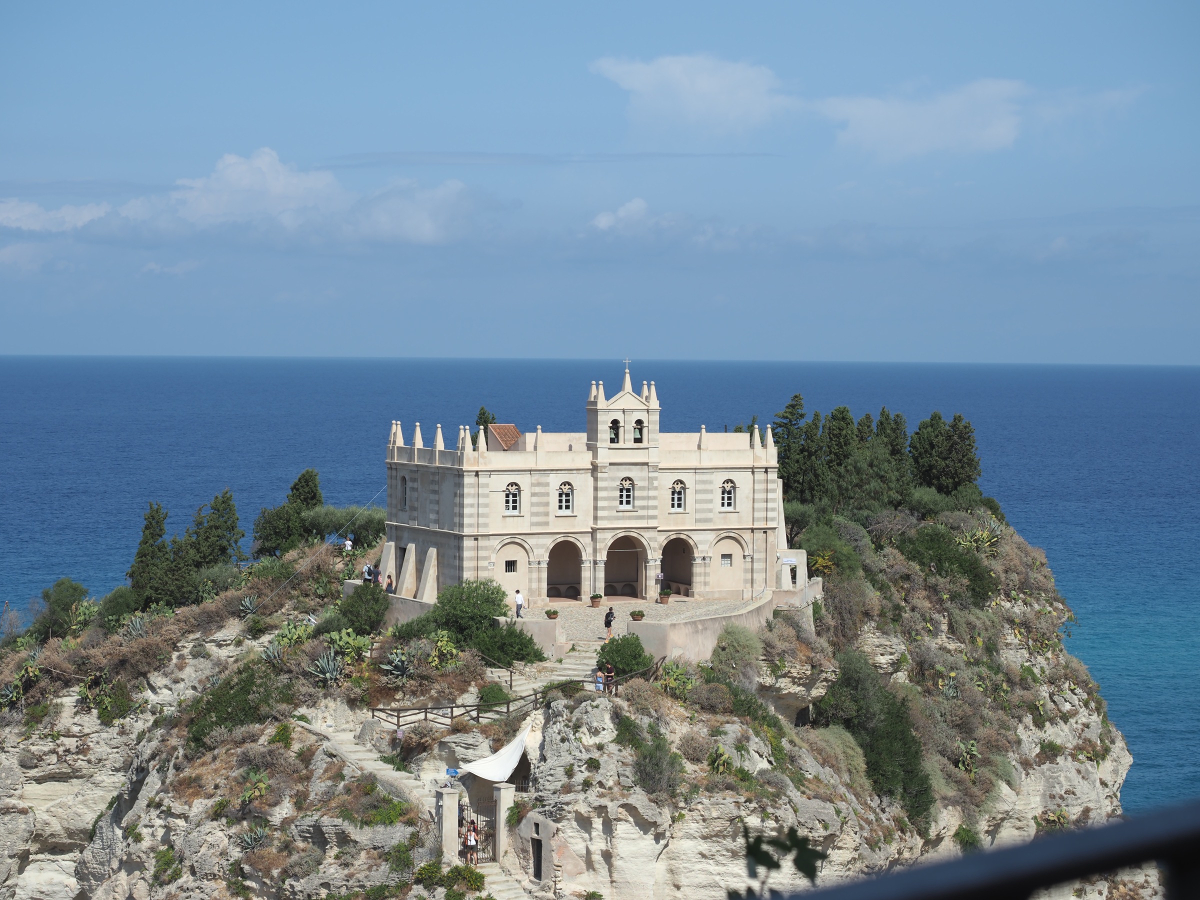Santa Maria dell’Isola auf dem Felsen vor Tropea, umgeben vom blauen Meer.