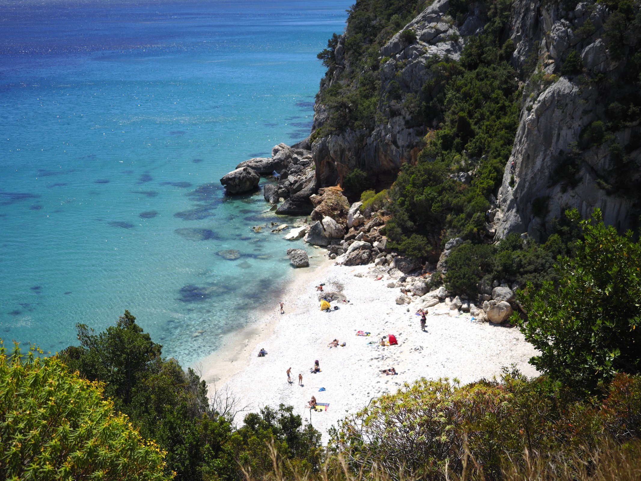 Türkisfarbenes Wasser und eine von Felsen eingerahmte Bucht auf Sardinien.
